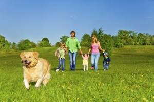 family walks with running dog in park